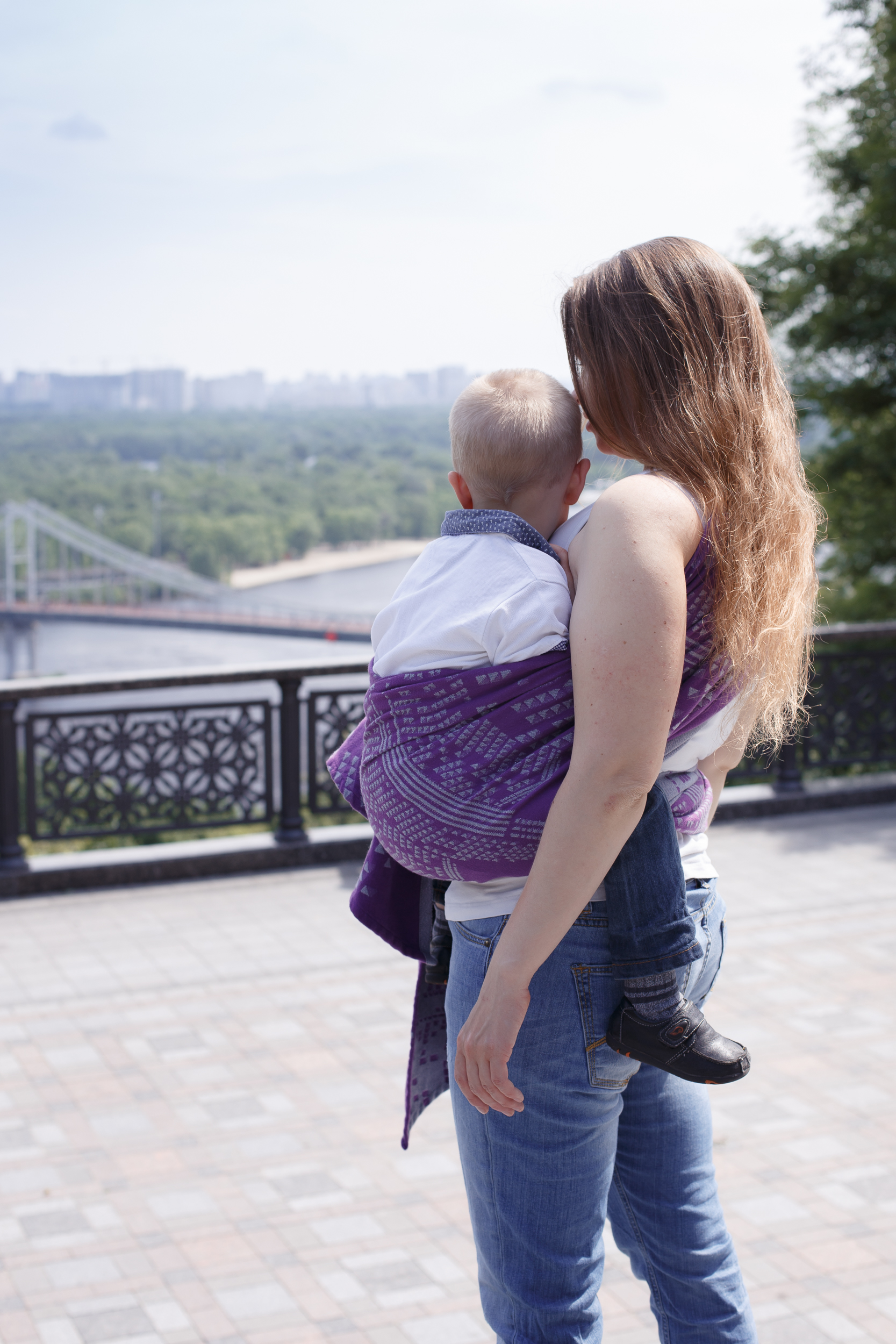 Woman carrying child in a woven wrap